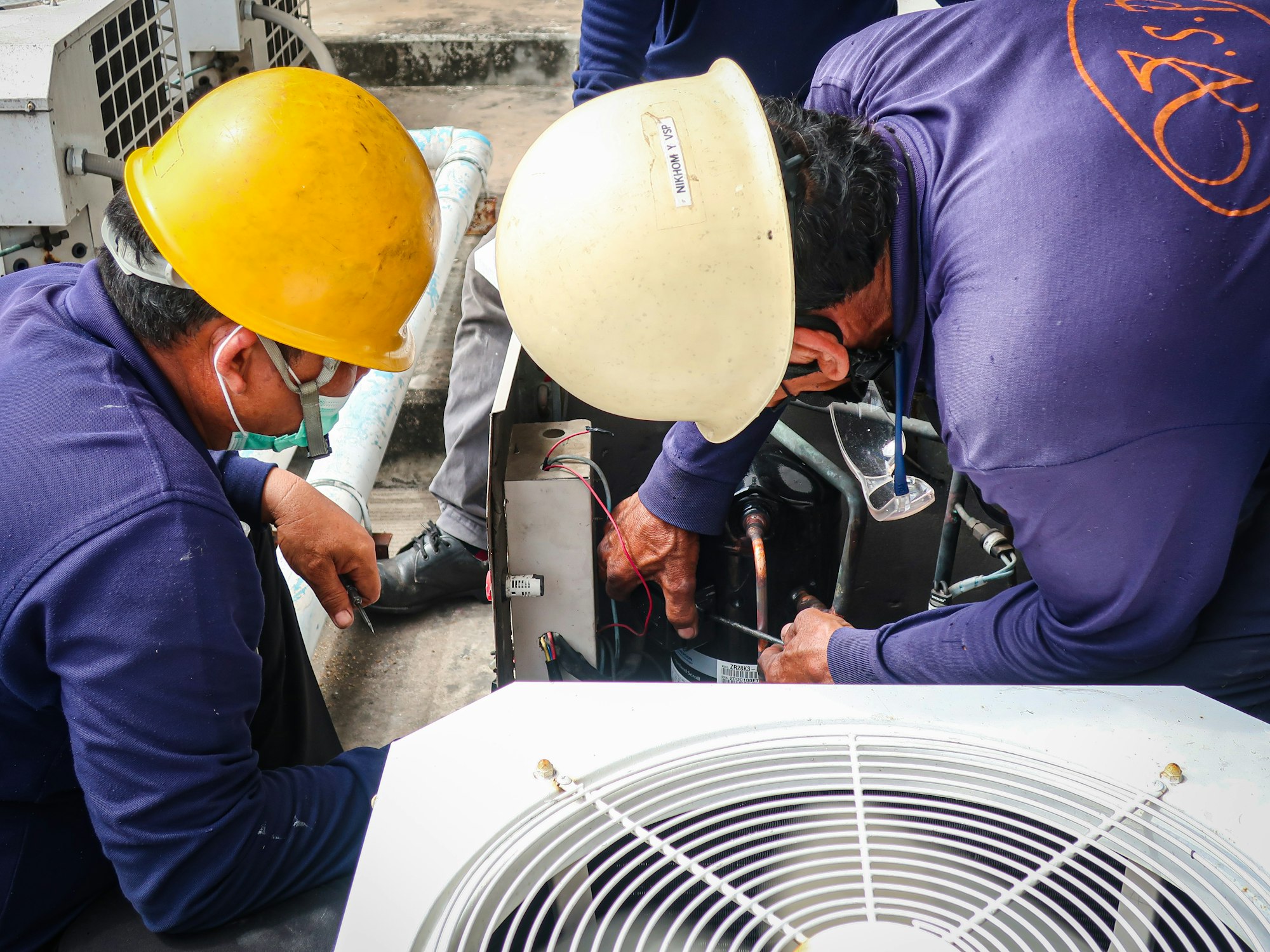 Maintenance man repair air conditional and air compressor of the factory.