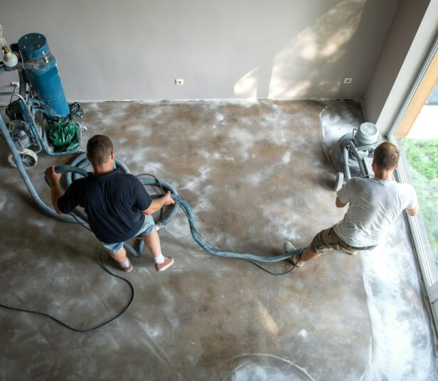 House restoration work, a two workers grinds concrete on the floor